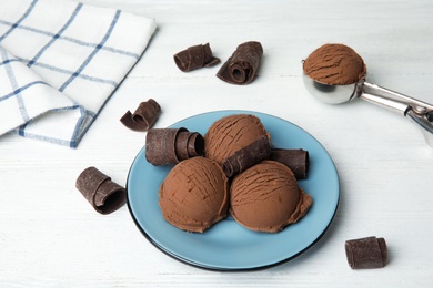 Photo of Composition with plate of ice cream and chocolate curls on white wooden table