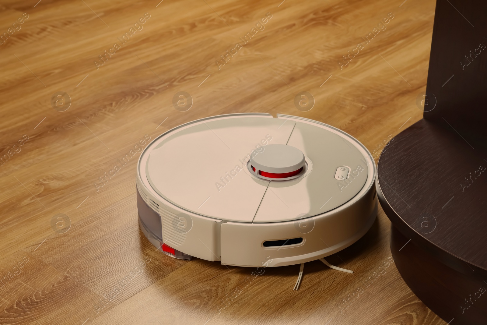 Photo of Robotic vacuum cleaner on wooden floor indoors