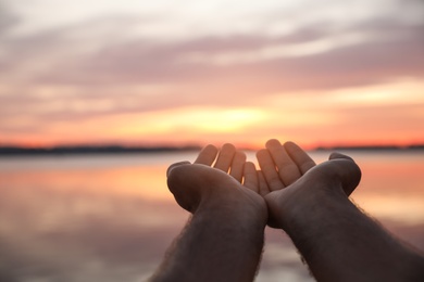 Man near river at sunset, closeup view. Nature healing power