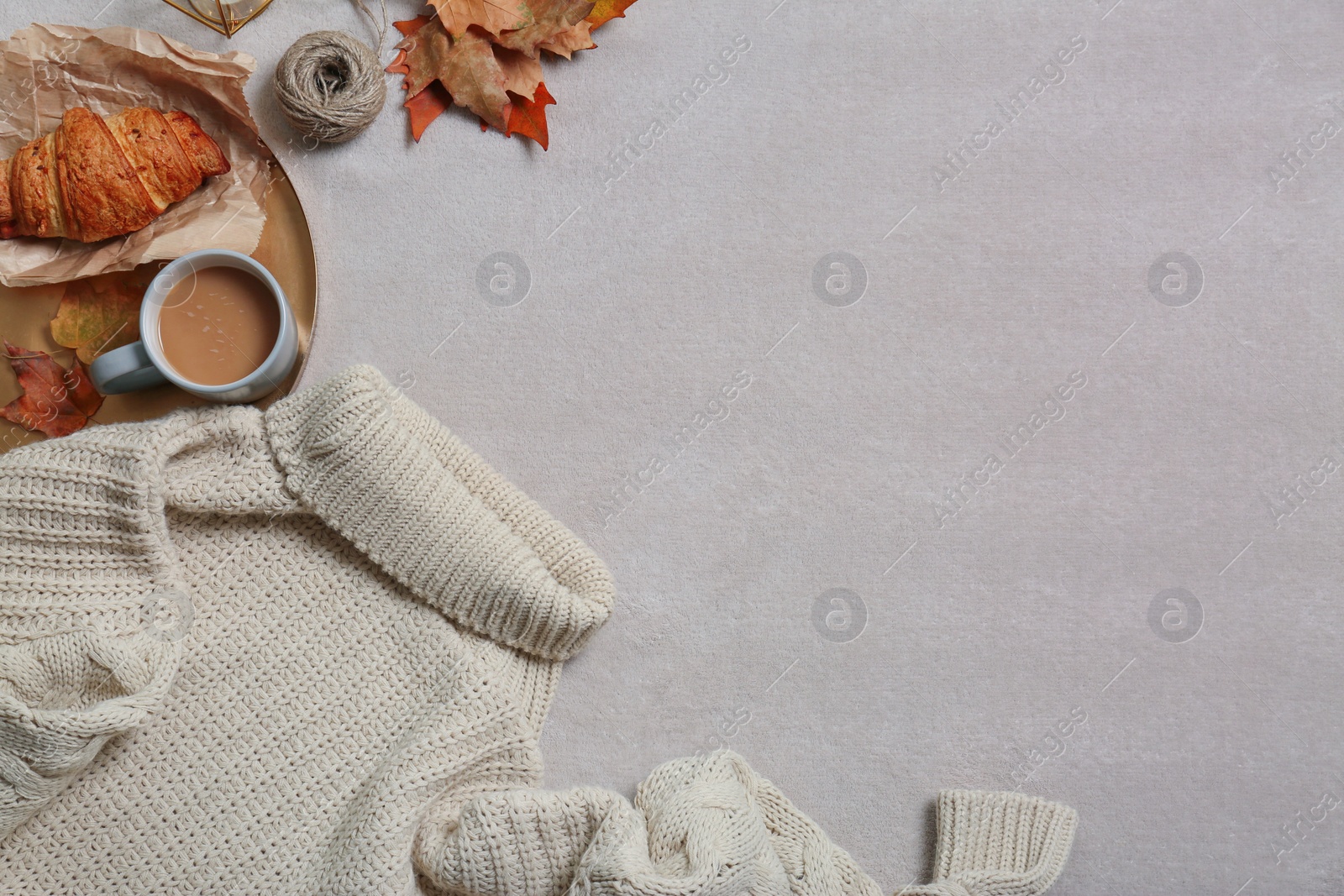 Photo of Flat lay composition with warm sweater and space for text on gray background