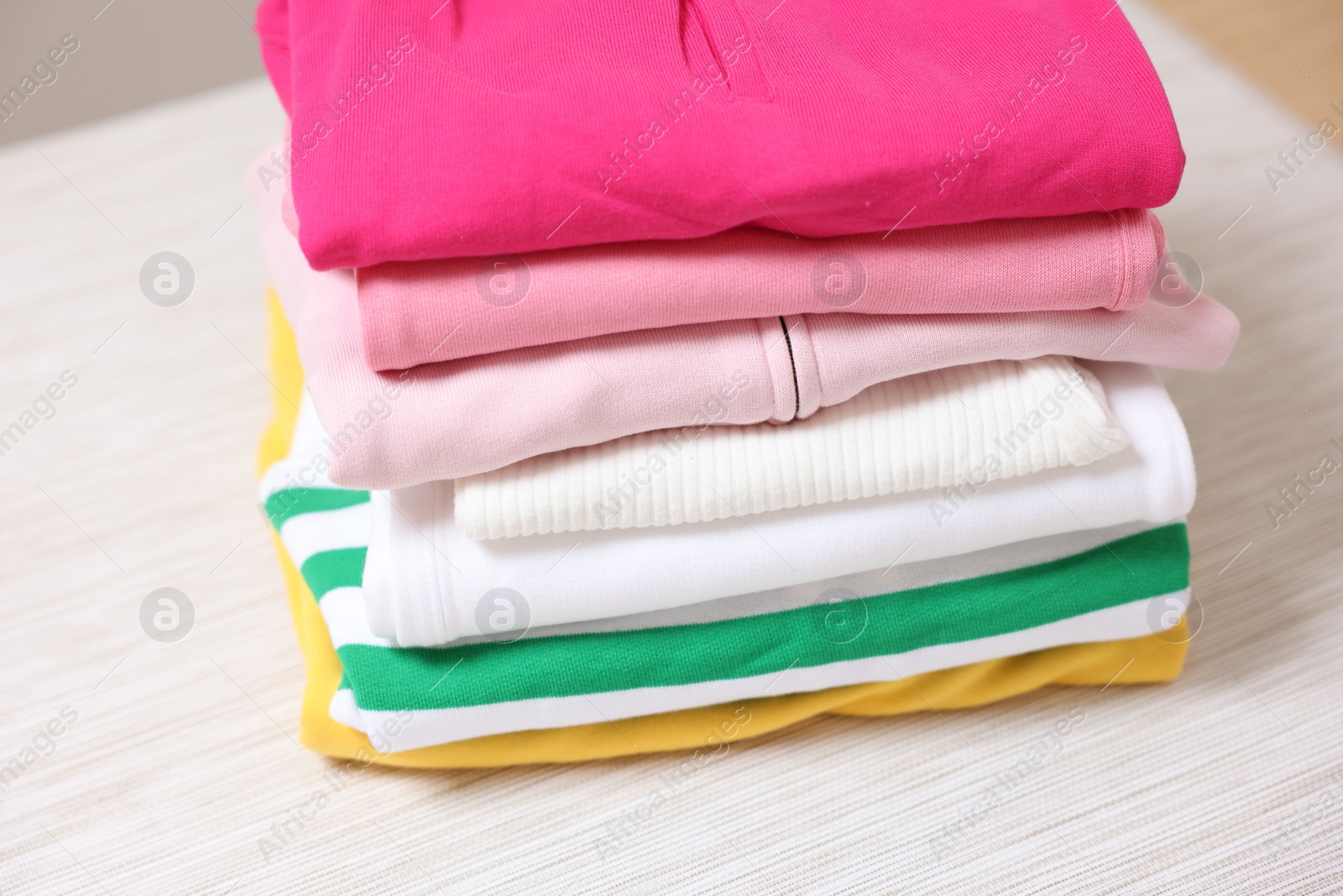 Stack of folded clothes on table, closeup Photo of Stack of folded clothes on table, closeup