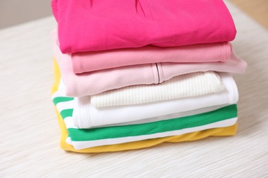 Photo of Stack of folded clothes on table, closeup