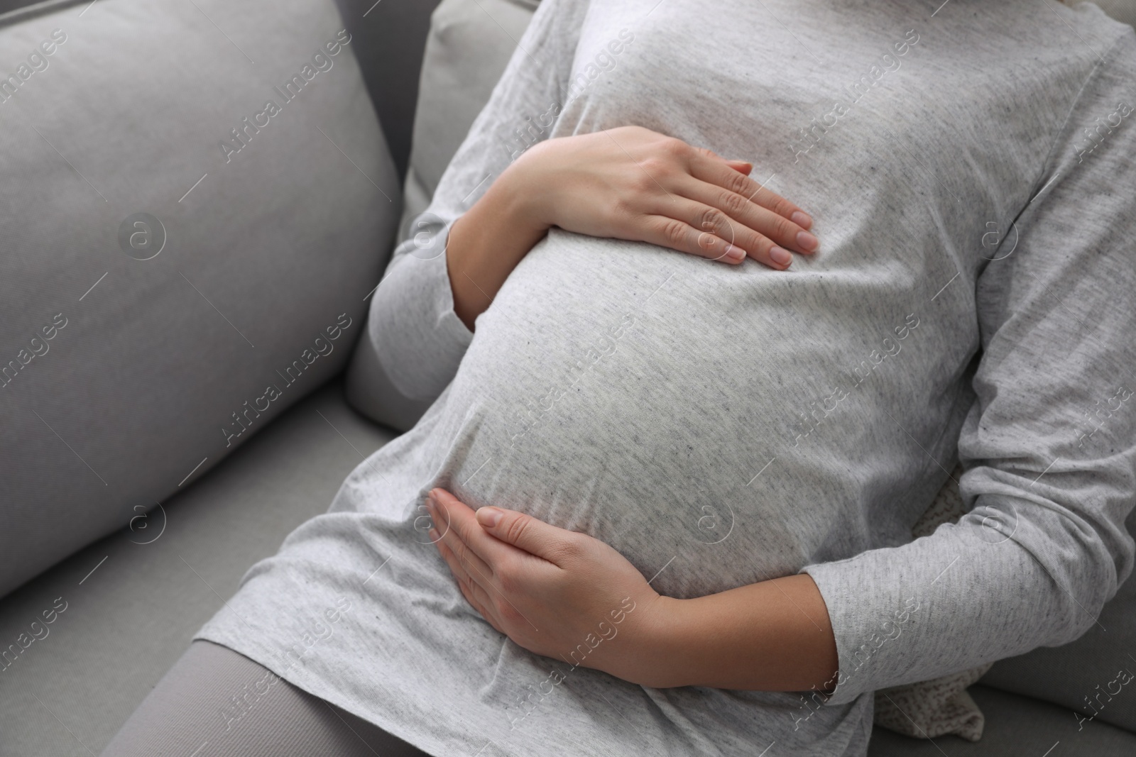 Photo of Pregnant woman resting on sofa, closeup view