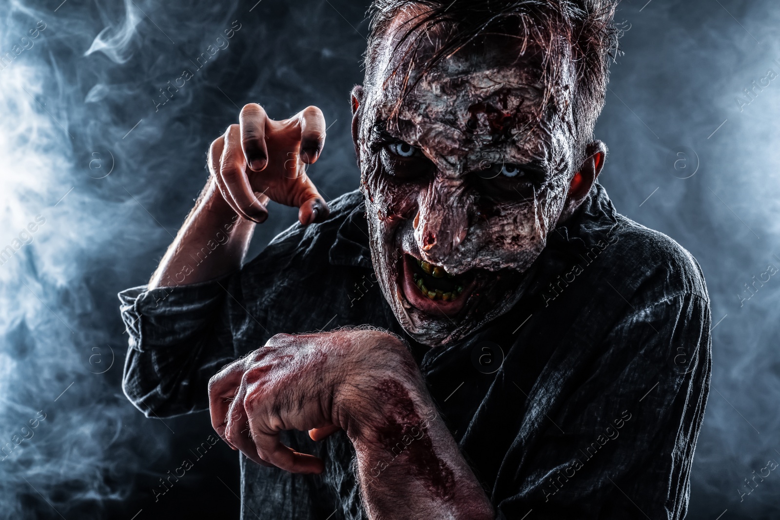 Photo of Scary zombie on dark background. Halloween monster