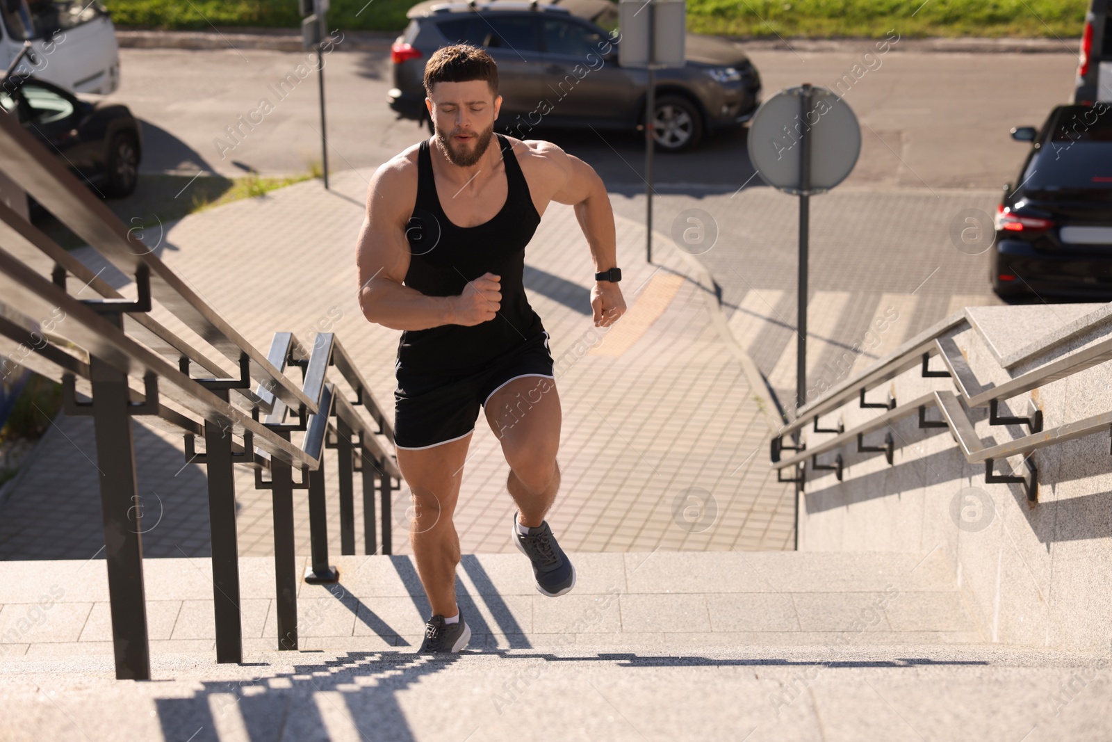 Photo of Man running up stairs outdoors on sunny day