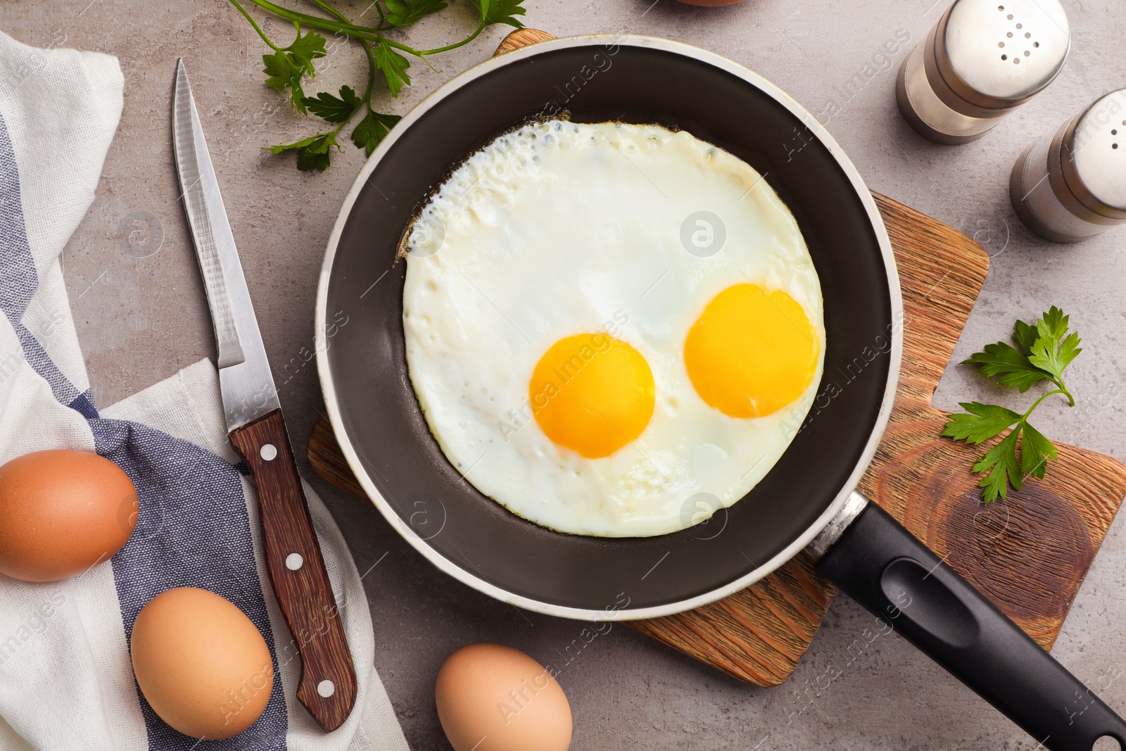 Photo of Pan with fried sunny side up eggs served on table, flat lay