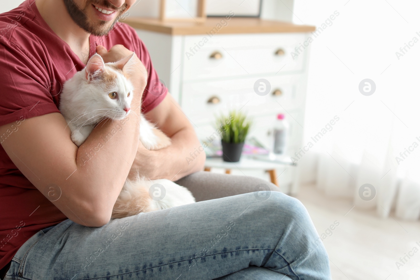 Photo of Young man with cute cat at home