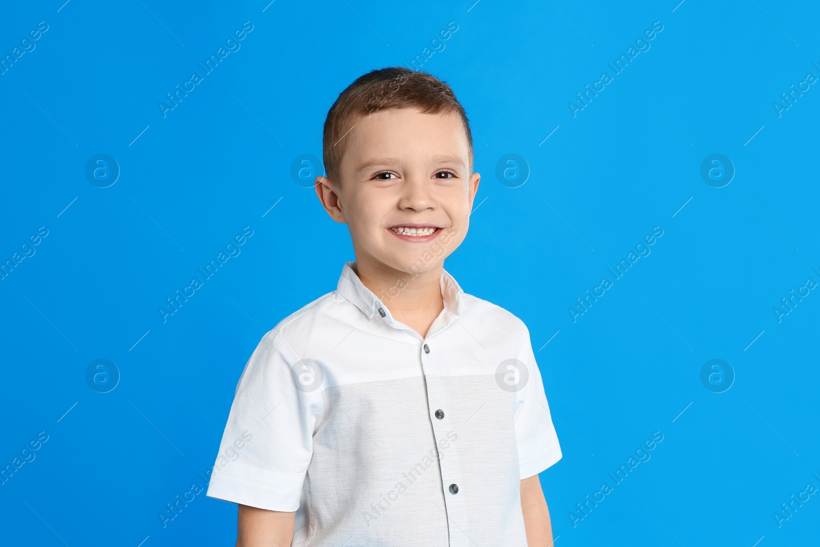 Photo of Portrait of cute little boy on blue background