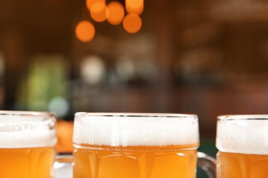 Photo of Glasses of tasty beer on blurred background, closeup