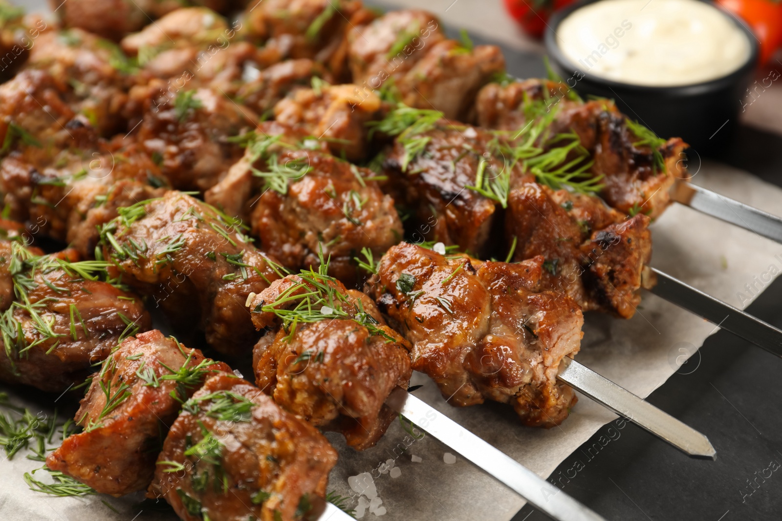 Photo of Metal skewers with delicious meat on table, closeup