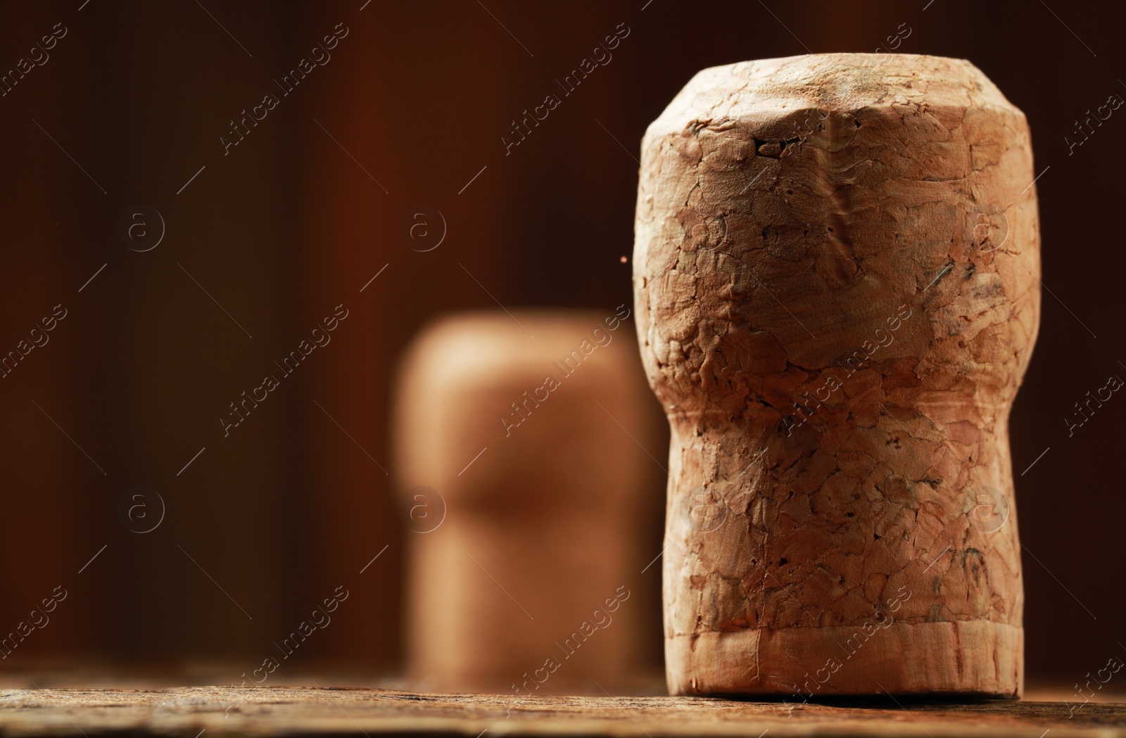 Photo of Cork of wine bottles on wooden table, closeup. Space for text