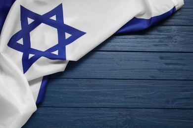 Photo of Flag of Israel on blue wooden background, top view and space for text. National symbol