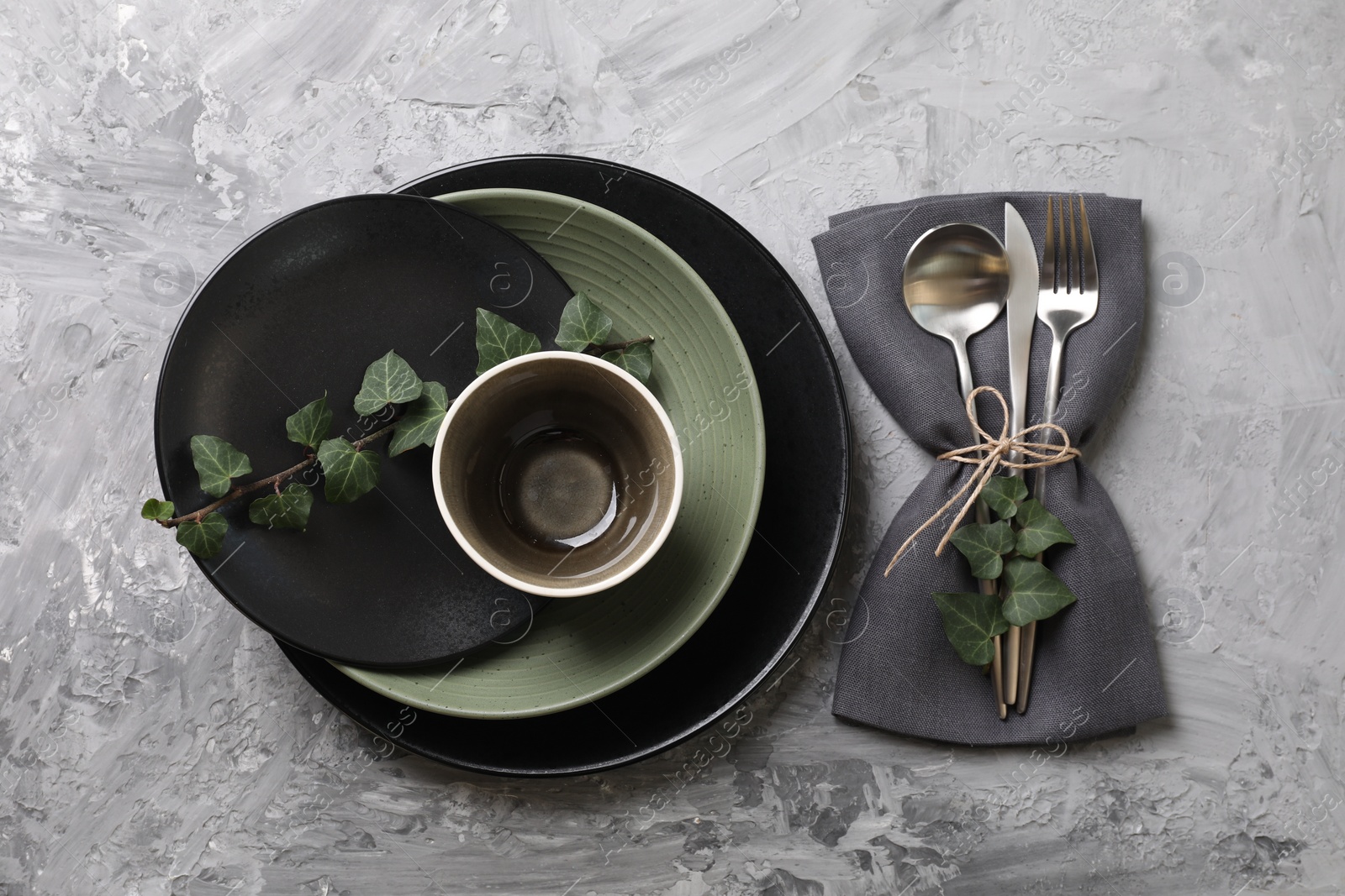 Photo of Stylish table setting. Dishes, cutlery, napkin and floral decor, top view