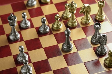 Wooden chessboard with game pieces, above view