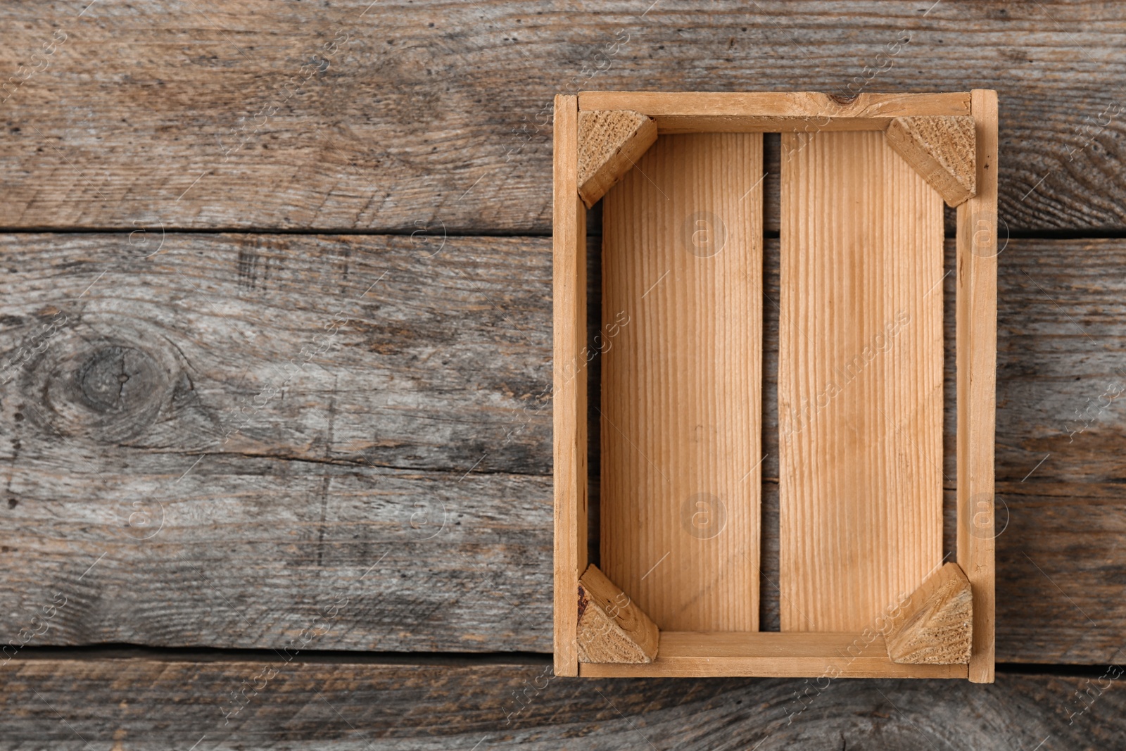 Photo of Empty crate on wooden background, top view with space for text