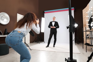 Photo of Handsome model posing for professional photographer in studio