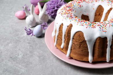 Glazed Easter cake with sprinkles on grey table, closeup. Space for text