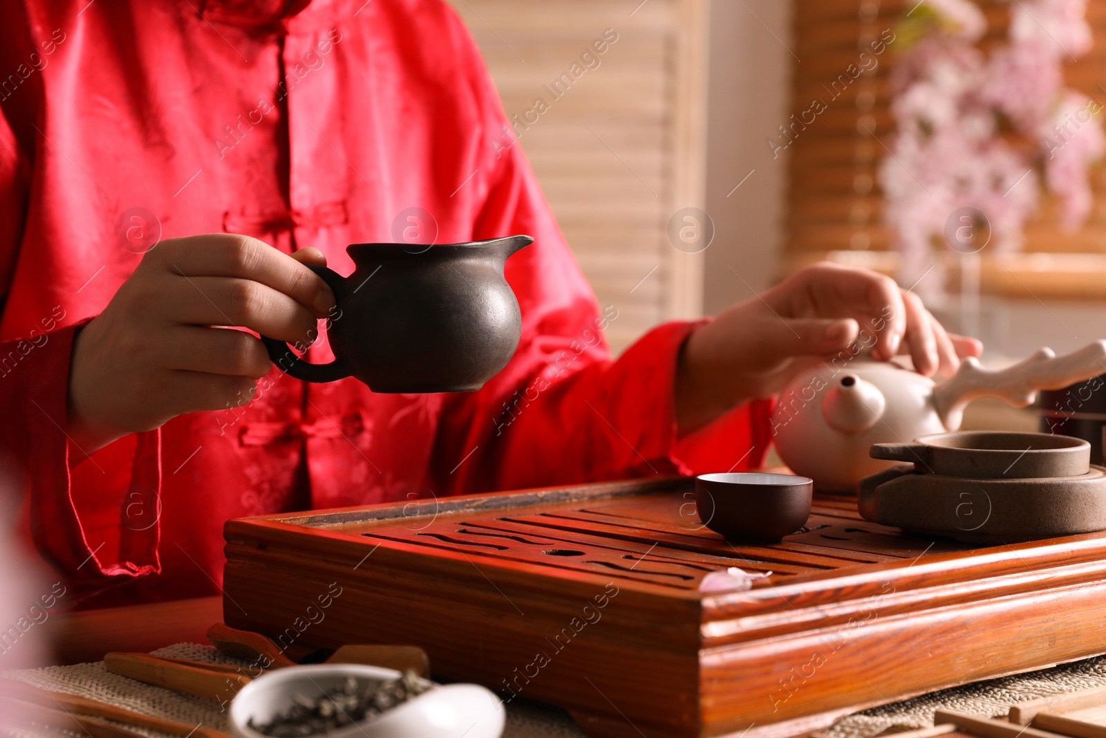 Photo of Master conducting traditional tea ceremony at table, closeup