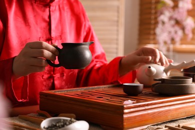 Master conducting traditional tea ceremony at table, closeup