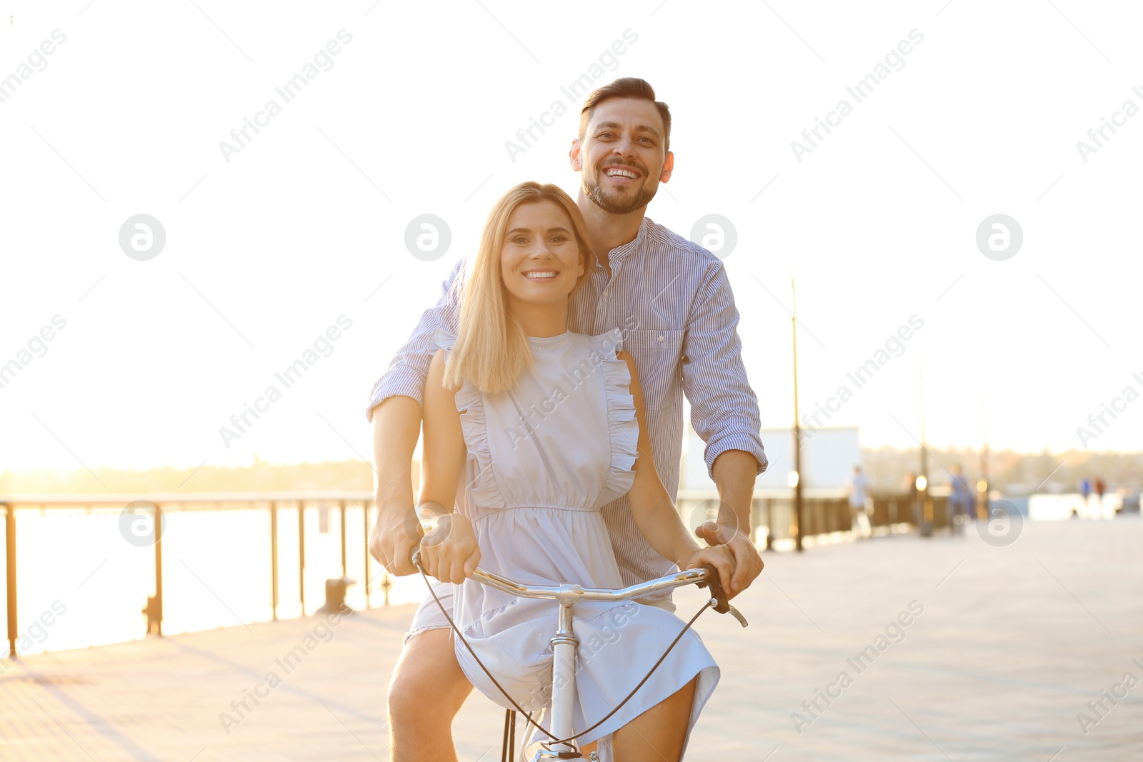 Photo of Happy couple riding bicycle outdoors on summer day