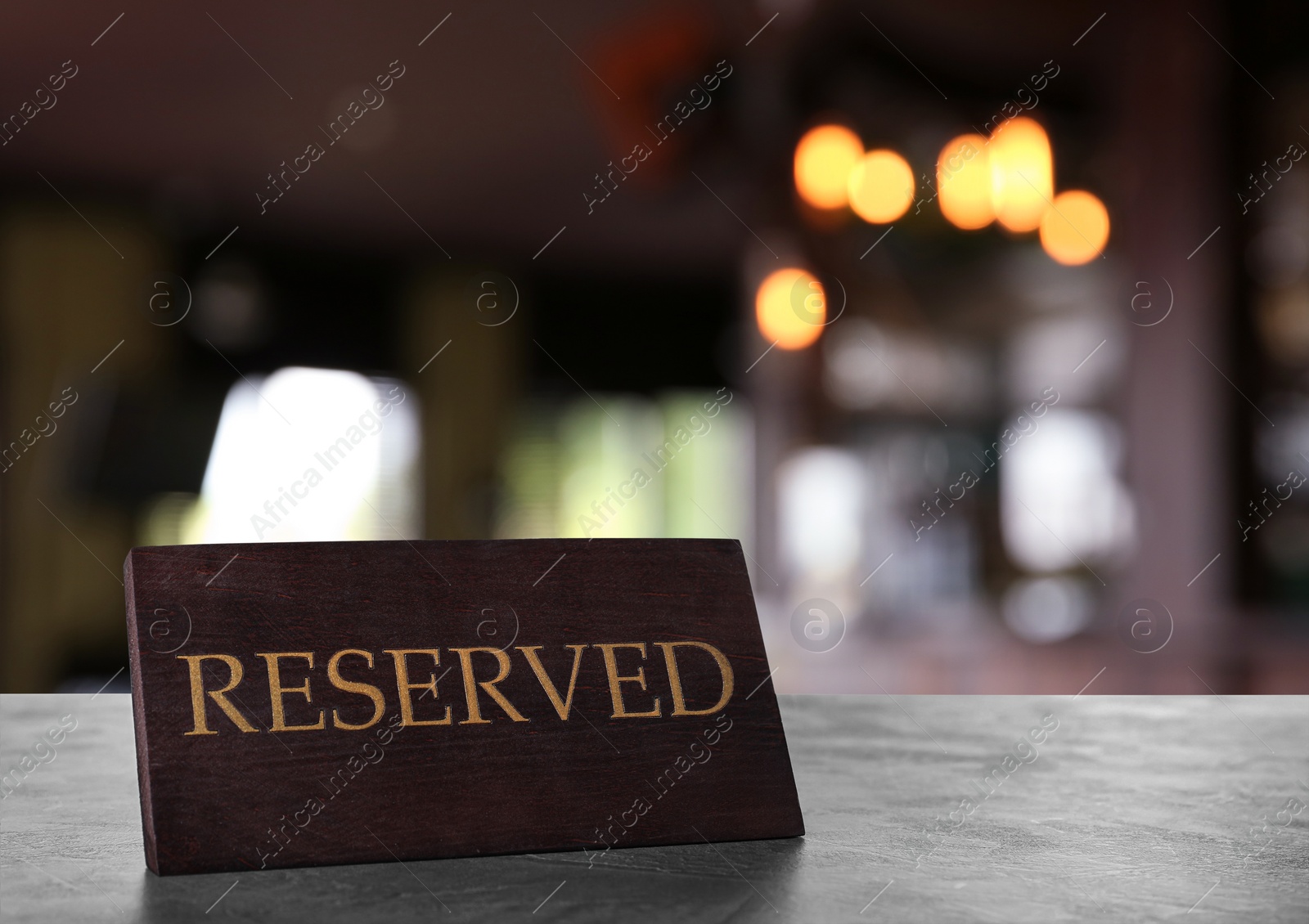 Image of Wooden sign Reserved on grey table in restaurant