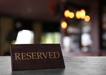 Wooden sign Reserved on grey table in restaurant
