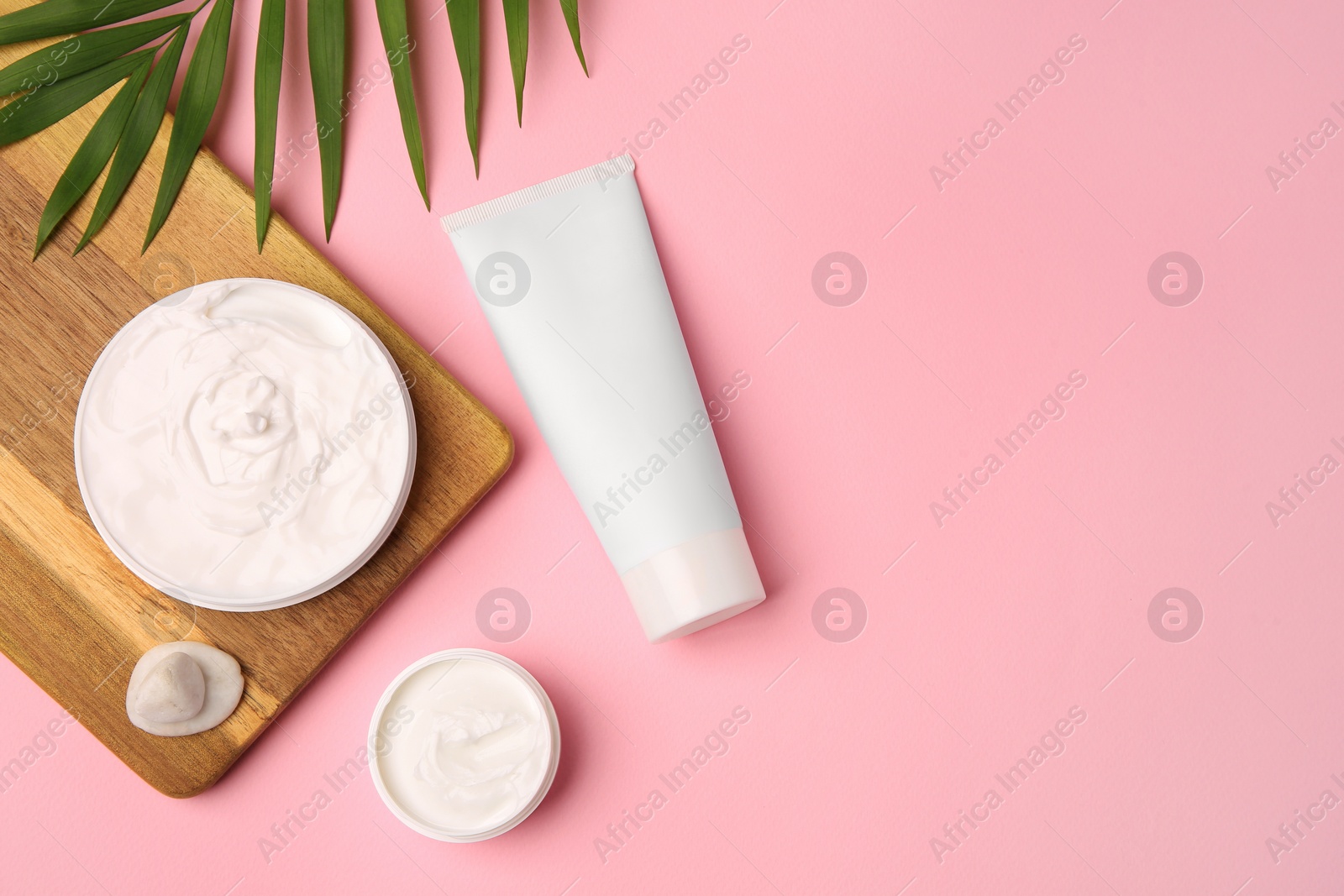 Photo of Flat lay composition with different cosmetic products on pink background. Space for text