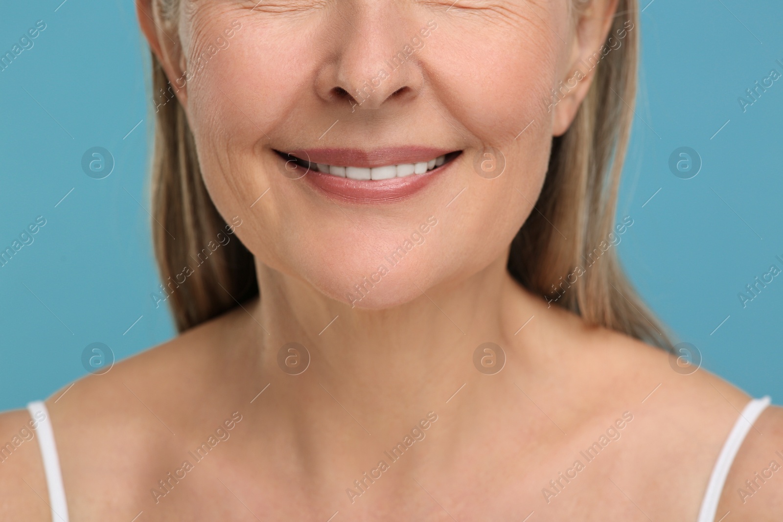 Photo of Senior woman with aging skin on light blue background, closeup. Rejuvenation treatment