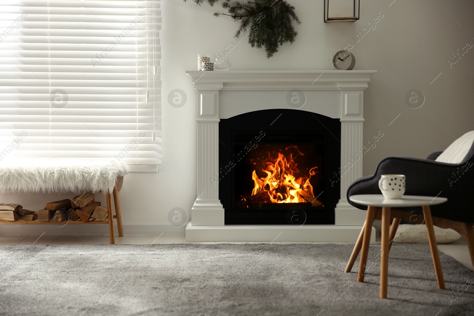 Photo of Bright living room interior with artificial fireplace and firewood