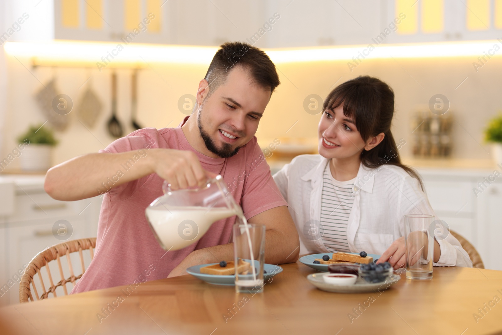 Photo of Happy couple having tasty breakfast at home