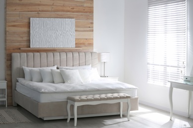 Photo of Comfortable bed with soft white pillows indoors