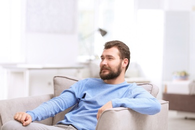 Portrait of confident mature man in armchair