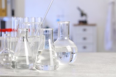 Photo of Laboratory analysis. Different glassware on light grey table indoors