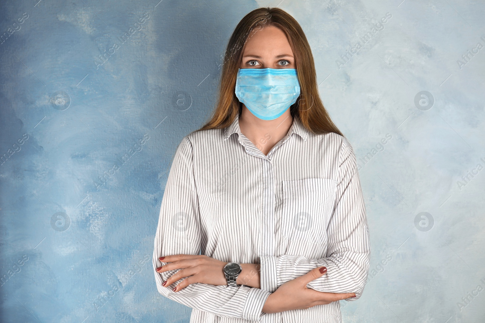 Photo of Woman with disposable mask on face against light blue background