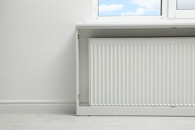 Photo of Modern radiator at home, space for text. Central heating system