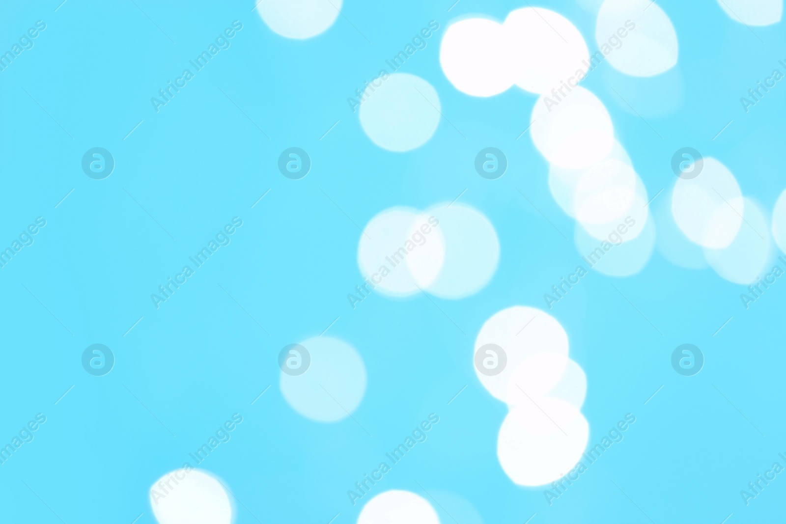 Photo of Beautiful blurred lights on cyan background, bokeh effect