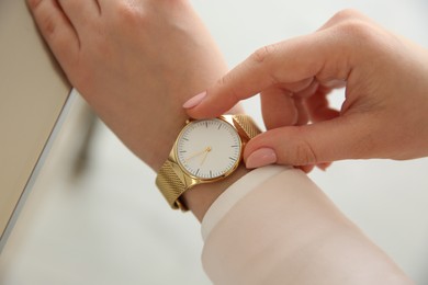 Photo of Woman with luxury wristwatch on blurred background, closeup