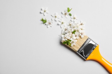 Photo of Paint brush and beautiful flowers on white background, flat lay. Space for text