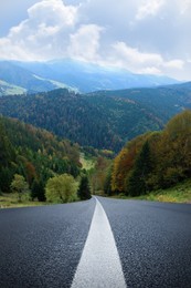 Beautiful view of forest and empty asphalt road leading to mountains