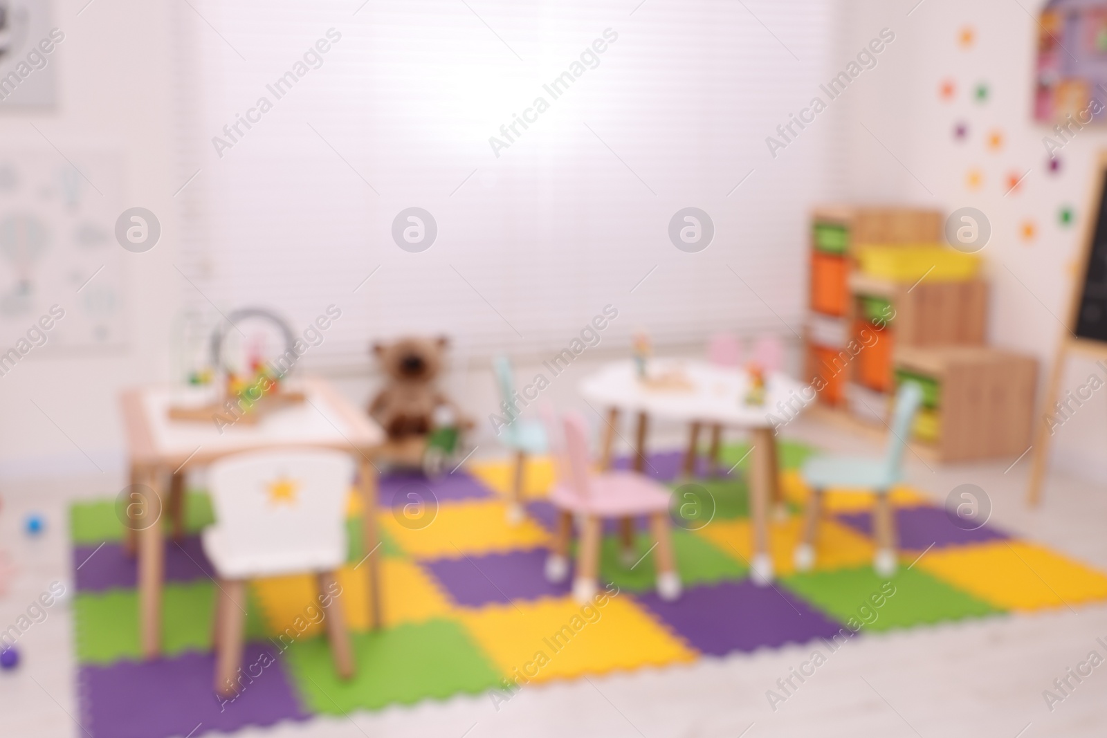 Photo of Stylish kindergarten interior with toys and modern furniture, blurred view