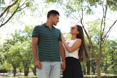 Lovely couple walking together in park on sunny day