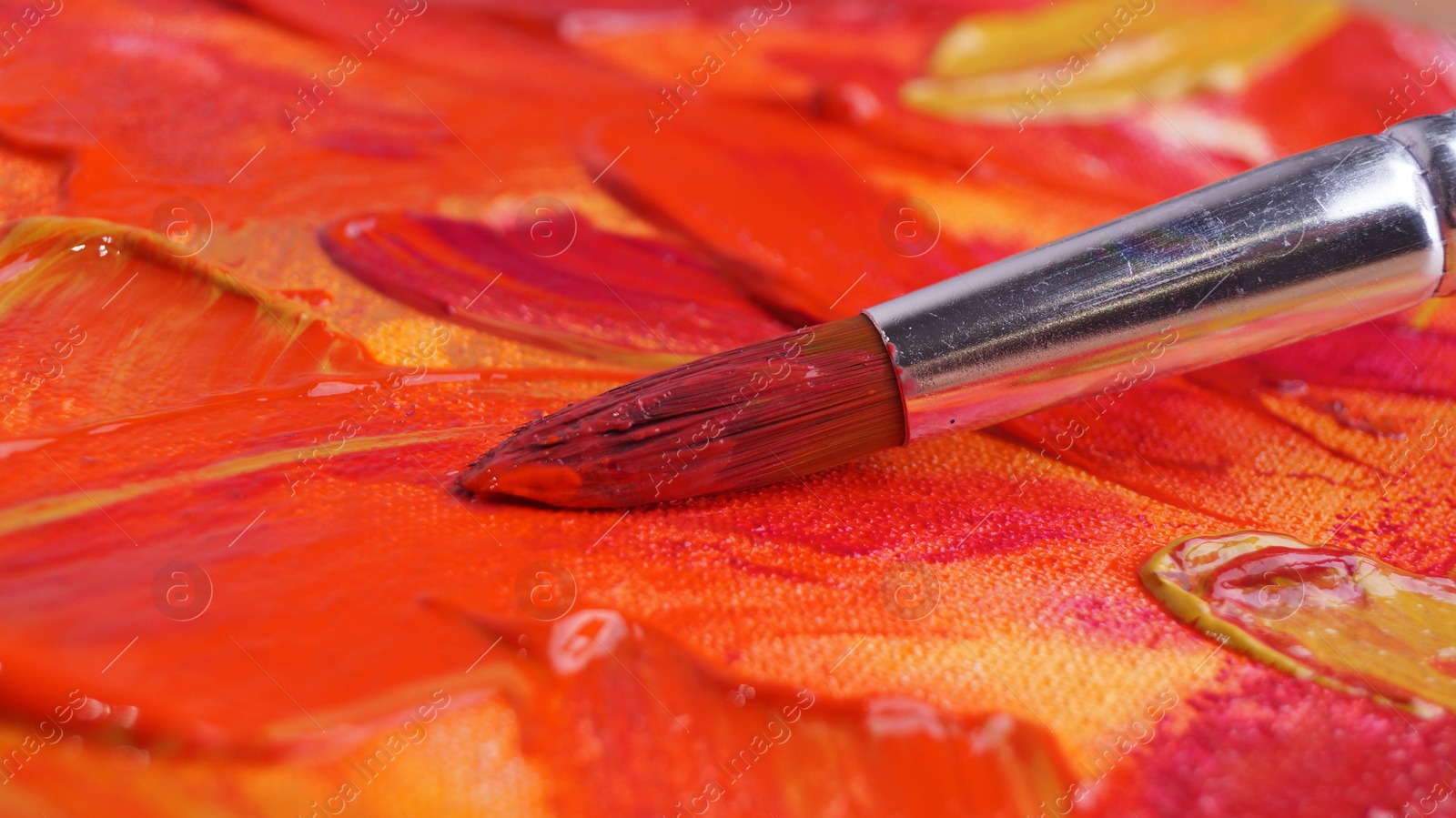 Photo of Brush on artist's palette with mixed paints, closeup