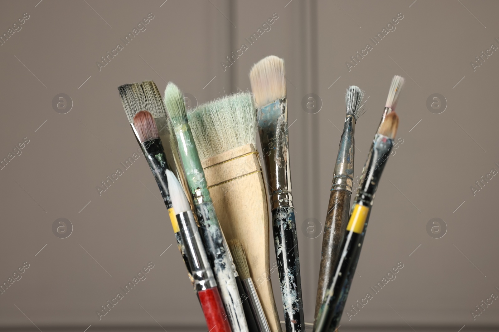 Photo of Set of different paintbrushes on grey background, closeup