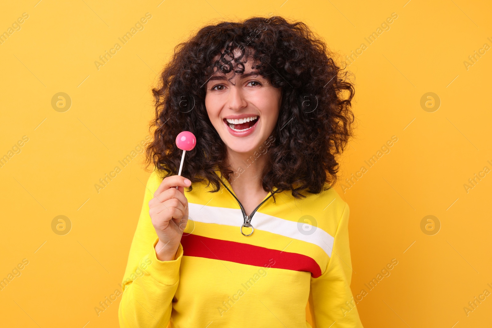 Photo of Beautiful woman with lollipop on yellow background