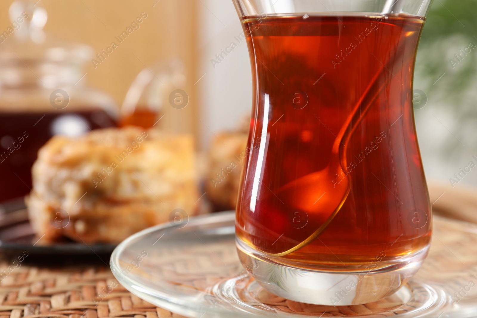 Photo of Traditional Turkish tea in glass on wicker table, closeup. Space for text