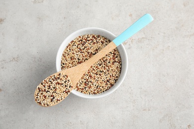 Photo of Bowl and spoon with mixed quinoa seeds on grey background, top view