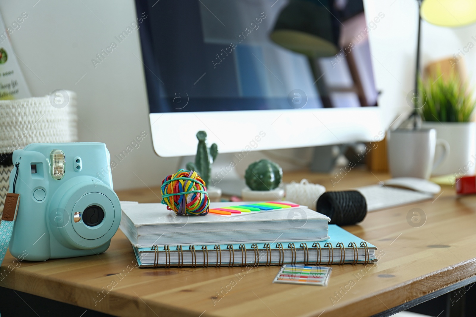 Photo of Digital camera and notebooks on table in studio. Modern designer's workplace