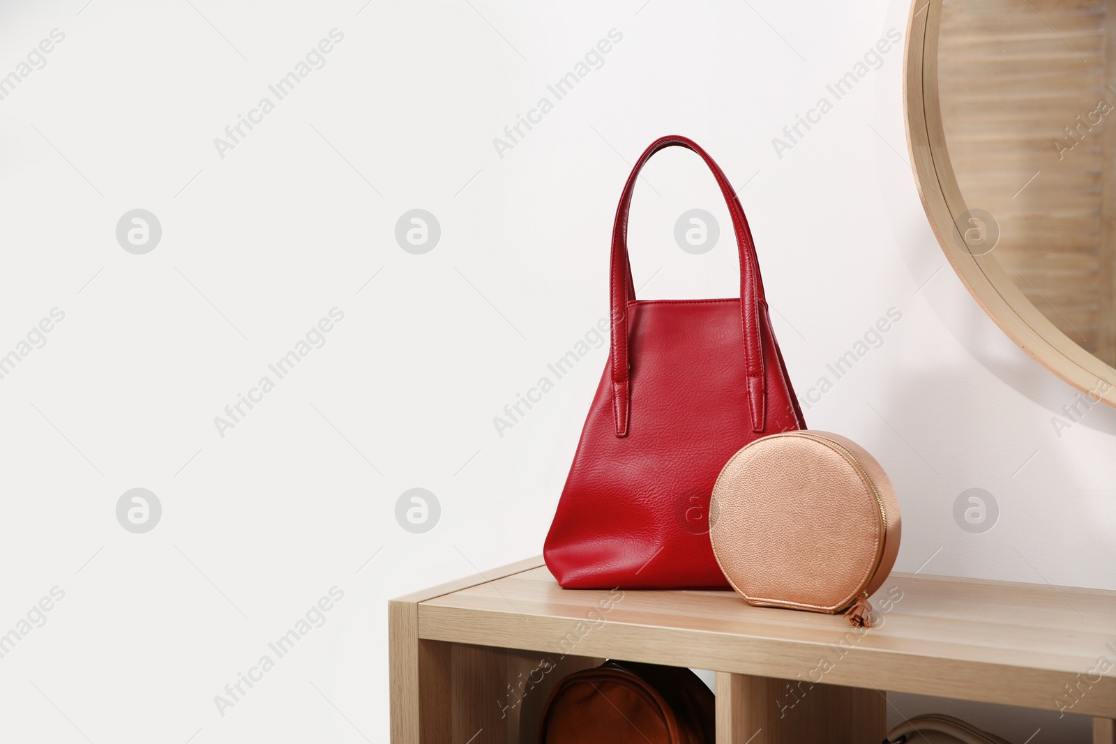 Photo of Different stylish woman's bags on wooden shelf