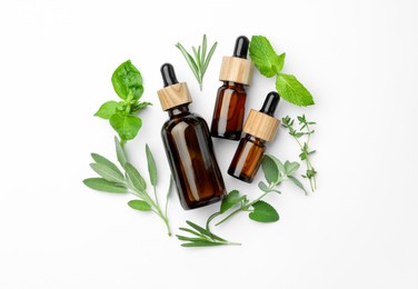 Photo of Bottles of essential oil and fresh herbs on white background, flat lay