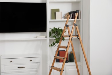 Wooden folding ladder in stylish living room